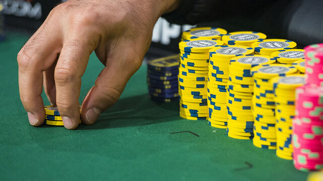 Hand Reaching to Place Casino Chip on Table