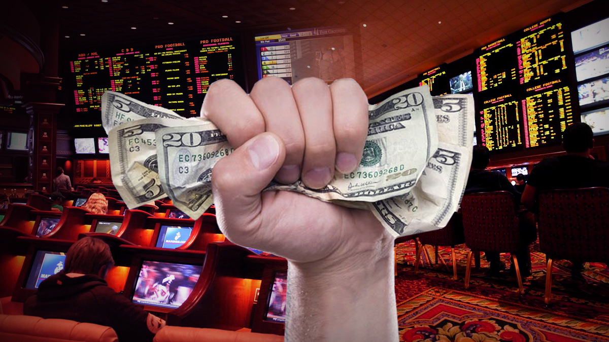 Hand Squeezing Money With a Sportsbook Background