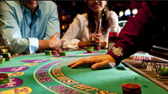 People Sitting at Table With Dealers Hand On Table